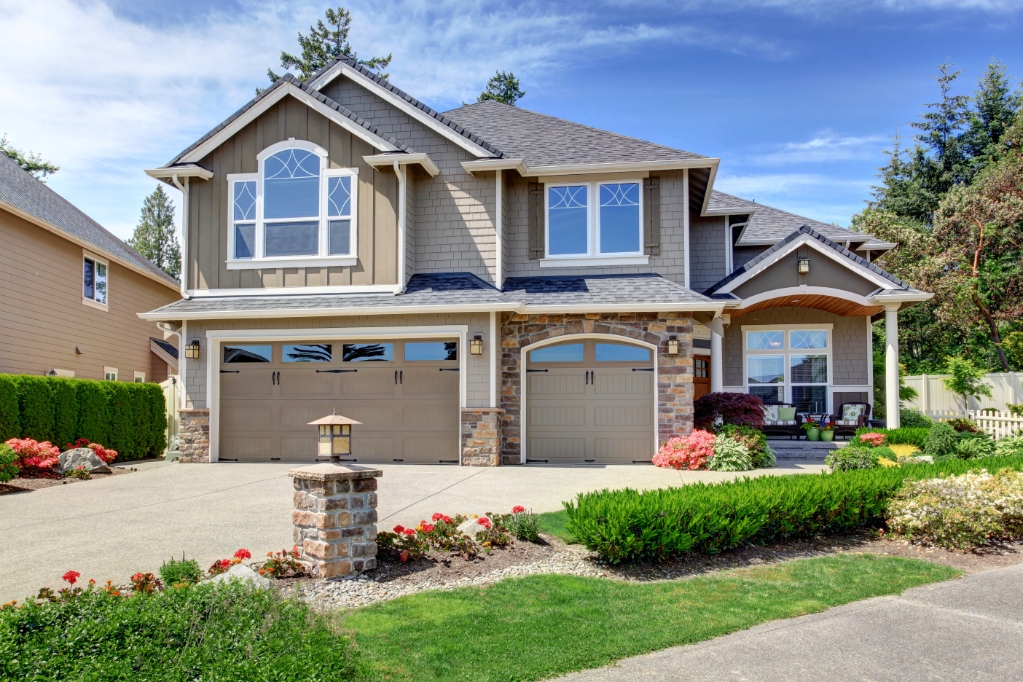 Large tan multilevel home with green landscape